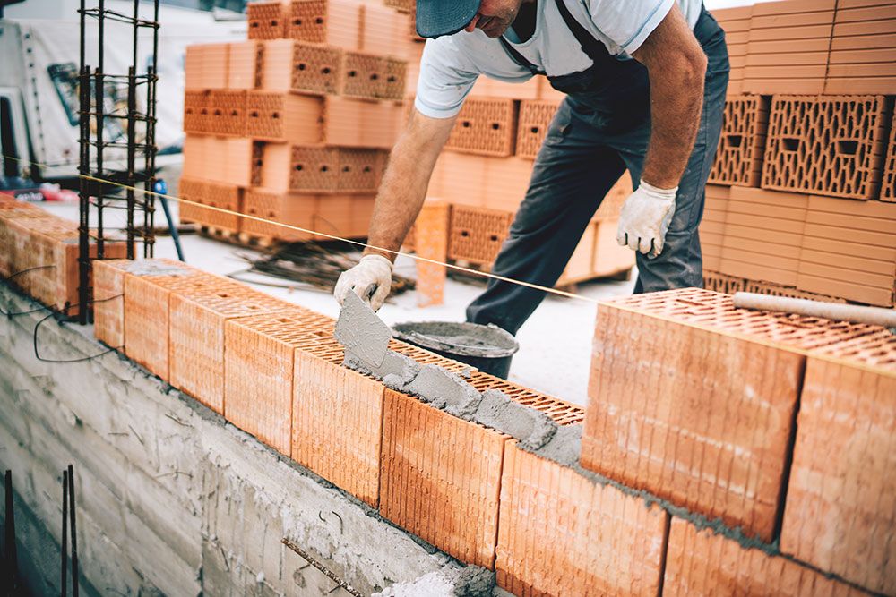 Ein Maurer baut eine Mauer